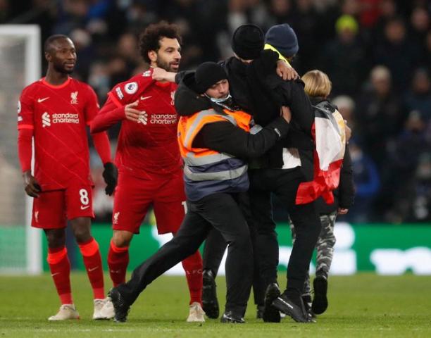 مشجع يحمل علم مصر يقتحم ملعب مباراة ليفربول ويتشبث بصلاح